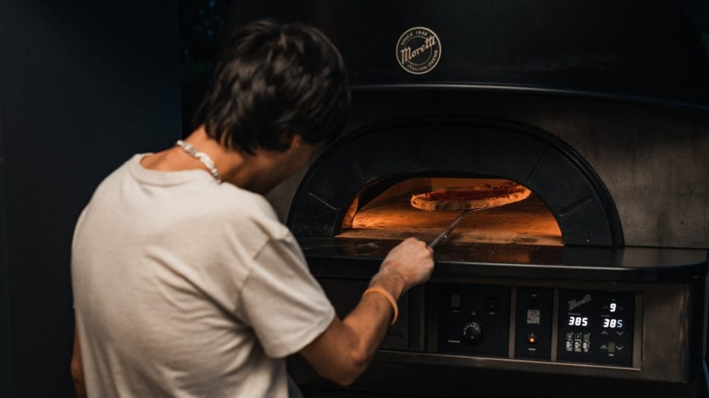 mann steker pizza på restaurant